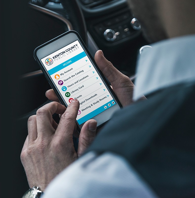 Photo - Homme en voiture utilisant l'interface Capira de la bibliothèque sur u téléphone