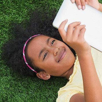 Foto: Niña leyendo en la mesa al aire libre