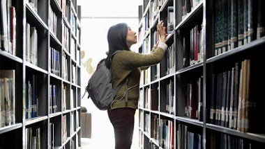 Usuario de la biblioteca observando los estantes
