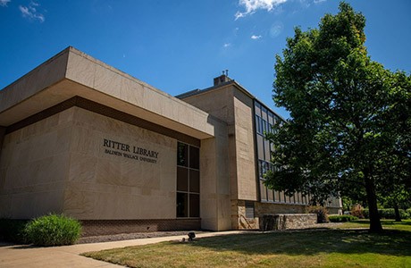 A building with the words, "Ritter Library, Baldwin Wallace University" stands tall on a sunny day.