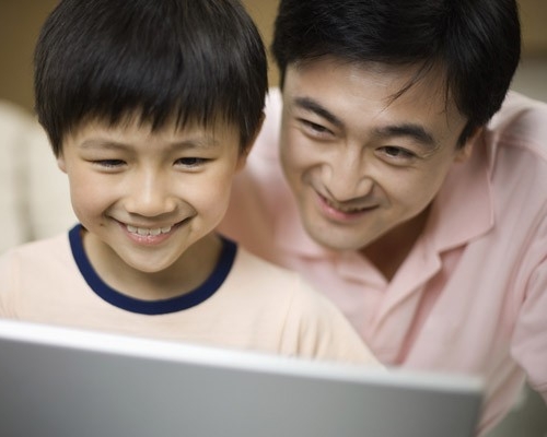 Père et fils regardant un écran